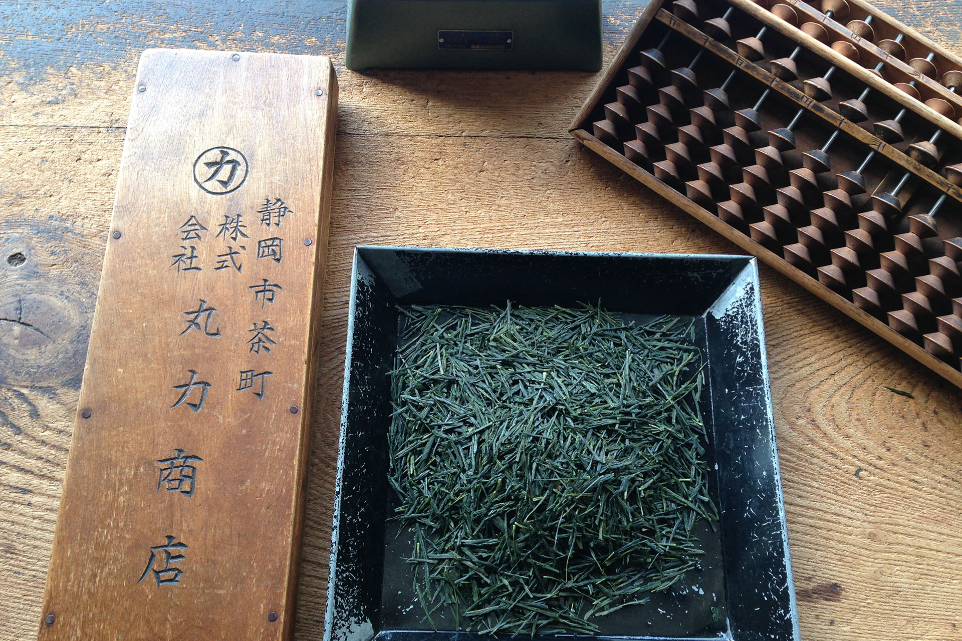 株式会社マルカの木板と茶葉とそろばん